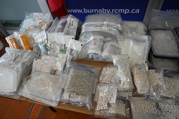 De nombreux sacs et boîtes de diverses drogues sont disposés sur une table.