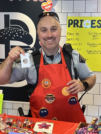 Photo of Mission RCMP officer inside McDonalds at a McHappy Day activity table