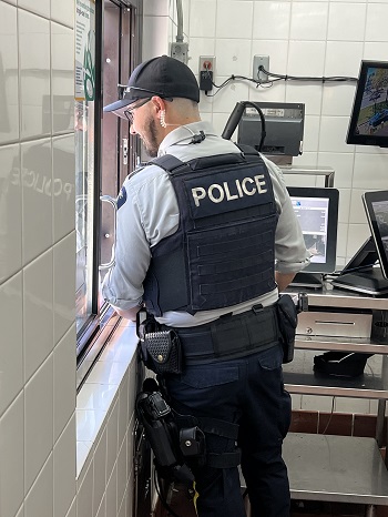 Photo of a Mission RCMP officer inside McDonalds serving a customer at a drive-through window