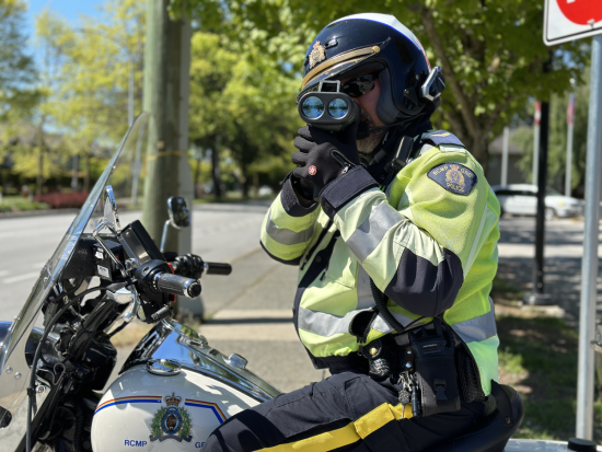 le caporal Peter Somerville sur sa motocyclette effectuant un contrôle de vitesse face à la caméra.