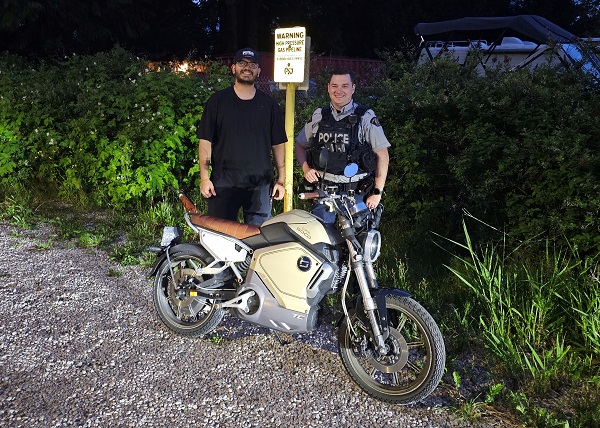 Le propriétaire, Atharva Sangani, et le gendarme Scott Shaw avec la motocyclette électrique récupérée.
