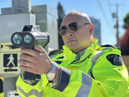 Agent de la GRC portant des lunettes de soleil et effectuant un contrôle de vitesse à une intersection