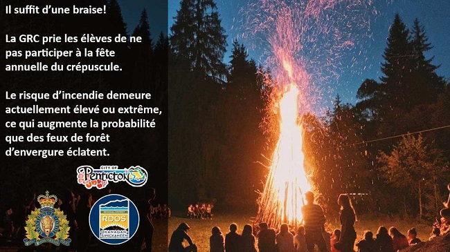 Photo d’un grand feu de camp autour duquel sont assis des jeunes. Voici le texte qui se trouve sur l’image : Il suffit d’une braise! La GRC prie les élèves de ne pas participer à la fête annuelle du crépuscule. Le risque d’incendie demeure actuellement élevé ou extrême, ce qui augmente la probabilité que des feux de forêt d’envergure éclatent. Sous le texte, on peut voir les logos de la Ville de Penticton, de la GRC et du district régional de l’Okanagan-Similkameen.