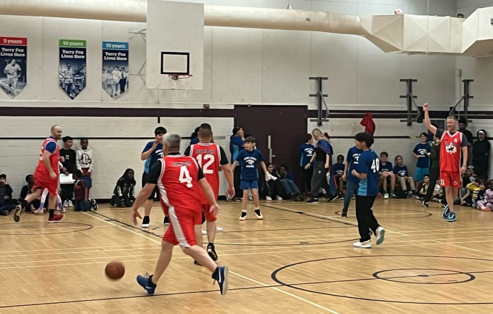 Photo of officers playing basketball with students