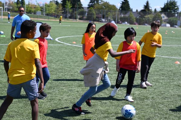 A group of kids play soccer outdoors