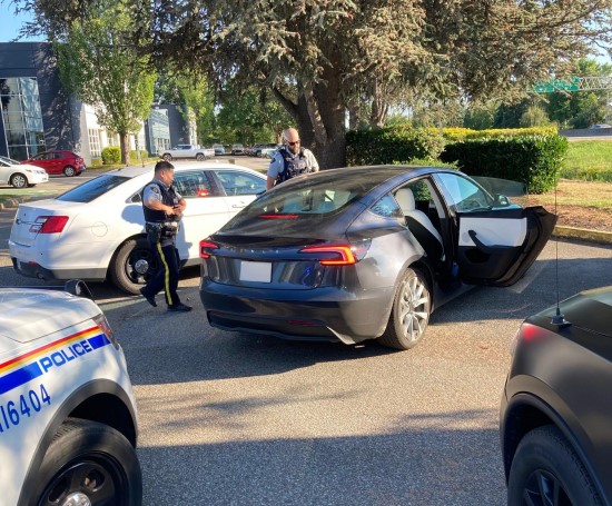 Two Richmond RCMP officers conducting vehicle check in parking lot