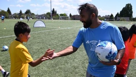 Smiling children with a soccer ball