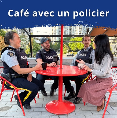 Des policiers sont assis autour d’une table à l’extérieur, boivent un café et parlent avec le public.