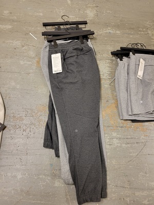 Men’s jogging pants on hangers piled on the ground