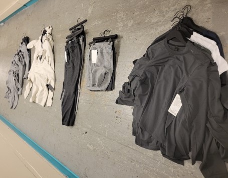 An assortment of athletic clothing including pants and shirts piled on the grounds