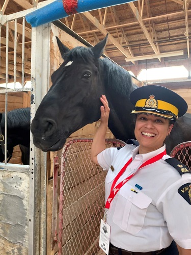 Inspector Veronica Fox posing with a Musical Ride horse