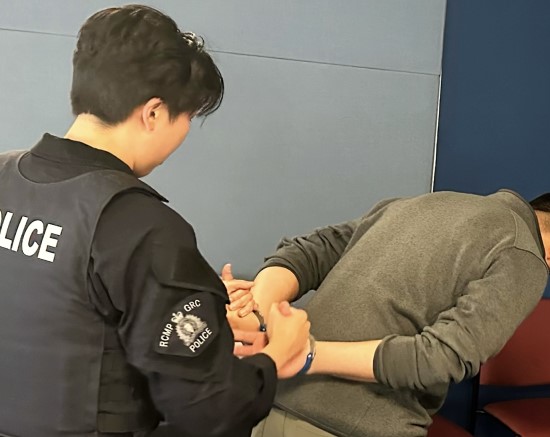 Constable Tsang demonstrating putting handcuffs on an individual