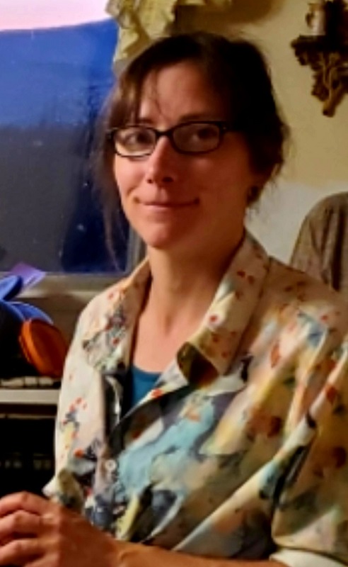 a woman with brown hair and glasses smiling