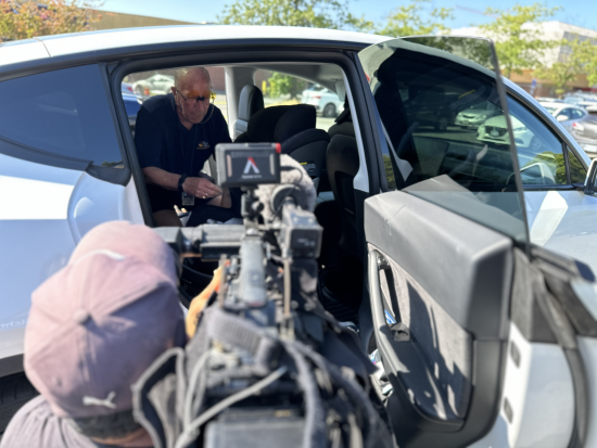 A volunteer demonstrating how to install a child car seat.