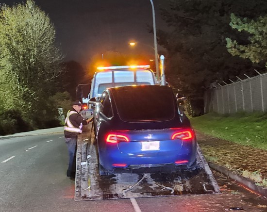 Voiture bleue chargée sur la plate-forme d’une dépanneuse