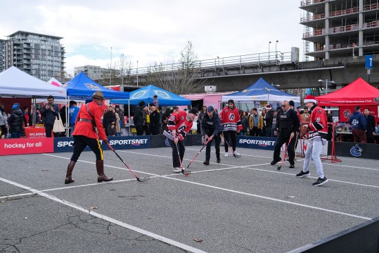 Des agents de la GRC et des membres des Sockeyes de Richmond jouent au hockey-balle avec des membres de la collectivité