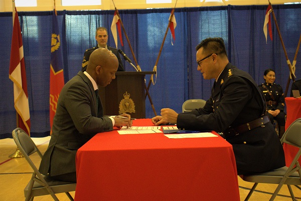 A member of EPO Troop #11 signing his engagement paperwork with the Human Resources Officer.