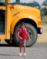 Une enfant qui traverse la rue après être descendue d’un autobus scolaire