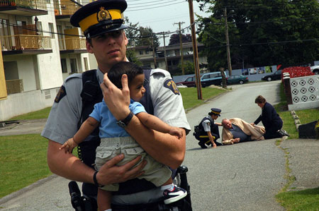 ضابط يحمل طفل بين يديه