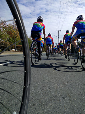 Une formation de cyclistes participant à la campagne « Policiers contre le cancer » circulant le long de la route