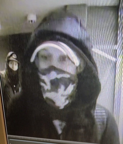 black and white photo of two suspects. Both wearing masks