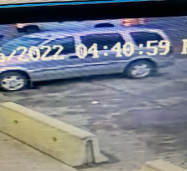 Video surveillance still with a grey van and half of a white 4 door truck in the photograph.