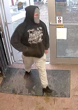 Man wearing black hoodie with Harlie Davidson loge, grey ski mask and light colour jogging pants entering business