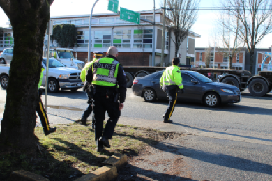 Quatre policiers dans la rue mènent une opération de prévention contre la distraction au volant.