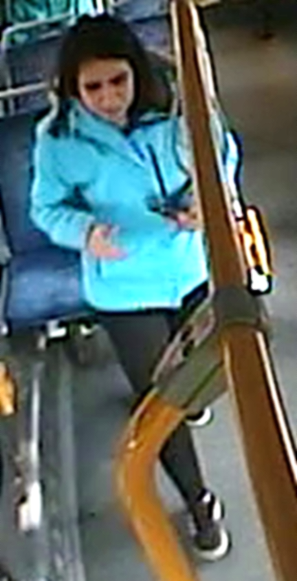 Female in blue jacket standing on the bus
