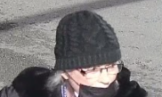 Photo tirée de la vidéo montrant le visage de la suspecte portant un masque, une tuque et des lunettes