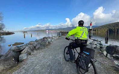 Bike patrol member on trail beside water
