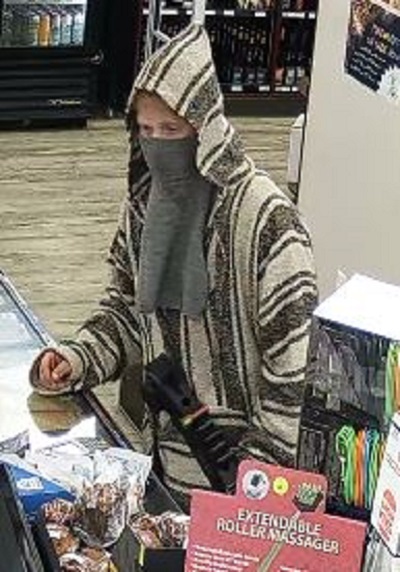 Male robbery suspect wearing a brown and beige vertical striped Mexican style poncho with a grey balaclava