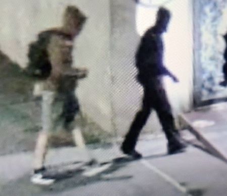 Suspects outside: a suspect in a brown or green hoodie and shorts with a backpack next to a person in dark clothing, walking outside. 