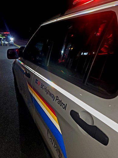 Photo prise de soir et montrant l’arrière d’un véhicule de police identifié de la GRC, du côté du conducteur. On y voit l’inscription « BC Highway Patrol » sur la portière.