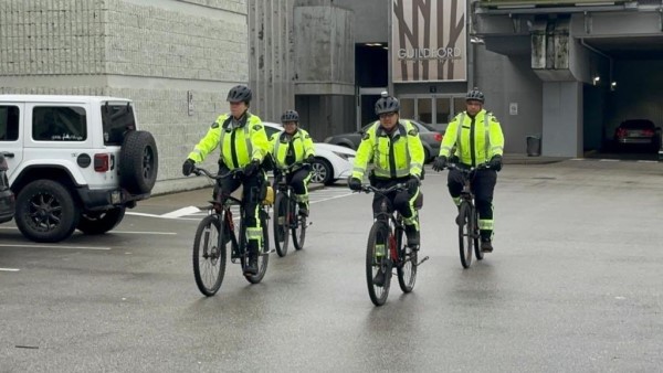 Quatre agents du GMCR du Détachement de la GRC de Surrey effectuent une patrouille à vélo dans le stationnement d’un centre commercial.