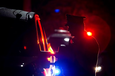Silhouette de nuit d’un agent de police et gyrophares rouge et bleu en arrière-plan