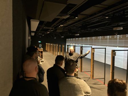 Group of several police officers and instructor standing at the gun range.