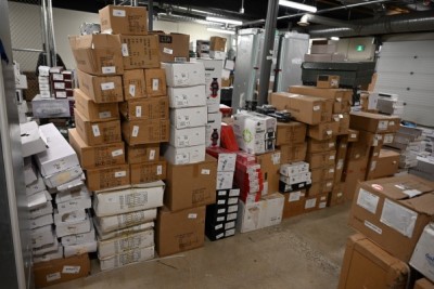 Dozens of cardboard boxes full of stolen items stacked up in a warehouse.